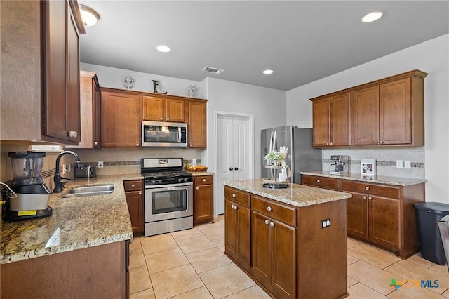 125 Flint Rock Ct, Victoria, TX 77904 - kitchen featuring appliances with stainless steel finishes, a sink, a center island, light tile patterned flooring, and recessed lighting