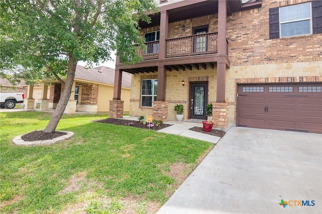 125 Flint Rock Ct, Victoria, TX 77904 - view of front of home with a balcony, a front lawn, an attached garage, concrete driveway, and brick siding