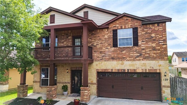 125 Flint Rock Ct, Victoria, TX 77904 - view of front facade featuring a balcony, stone siding, an attached garage, driveway, and brick siding