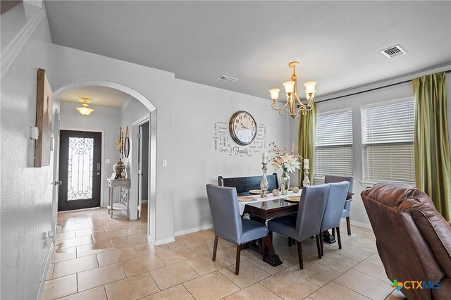 125 Flint Rock Ct, Victoria, TX 77904 - dining area featuring arched walkways, plenty of natural light, a chandelier, and light tile patterned floors