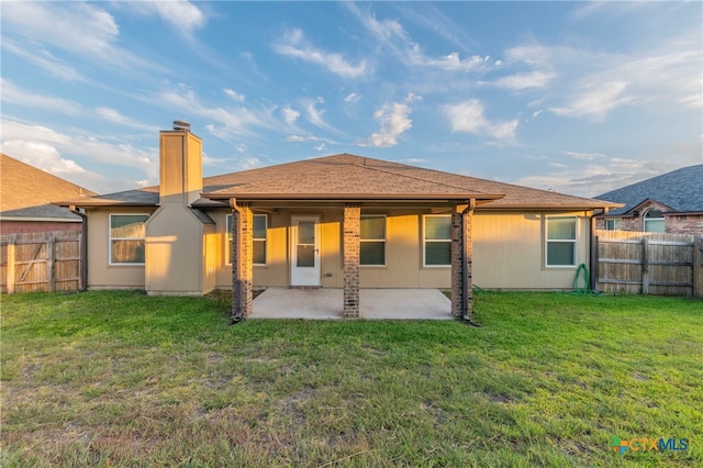 back of property featuring a patio and a yard