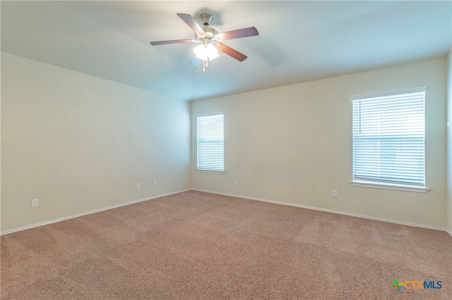 unfurnished room featuring light colored carpet, a healthy amount of sunlight, and ceiling fan