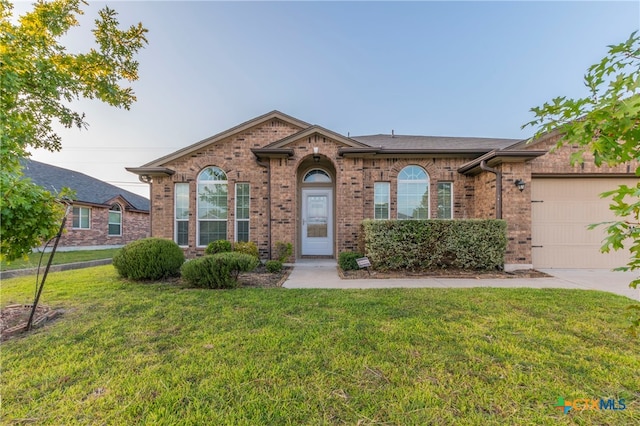 single story home with a garage and a front lawn