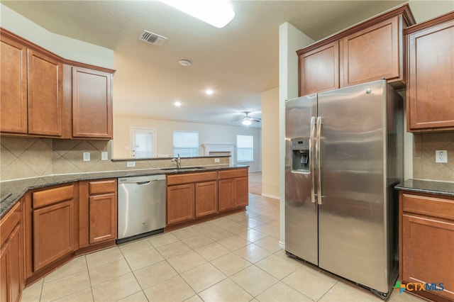 kitchen featuring appliances with stainless steel finishes, sink, tasteful backsplash, and light tile patterned floors