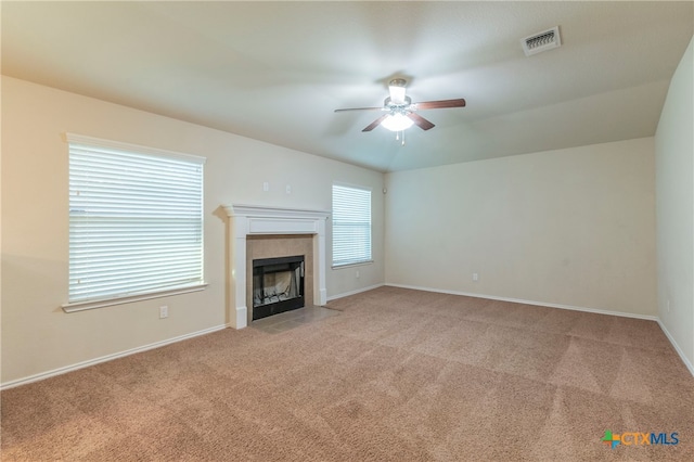 unfurnished living room featuring a fireplace, light carpet, and ceiling fan