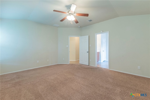 carpeted spare room featuring lofted ceiling and ceiling fan