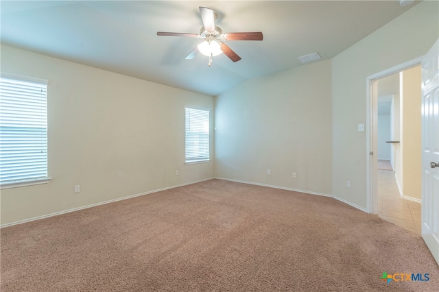 carpeted empty room featuring ceiling fan and vaulted ceiling