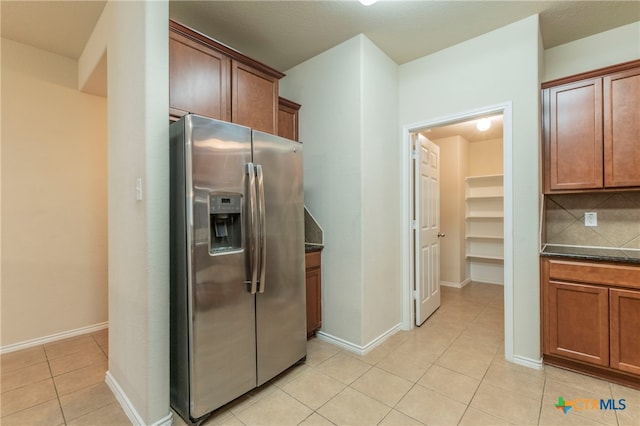 kitchen with decorative backsplash, stainless steel fridge with ice dispenser, and light tile patterned flooring