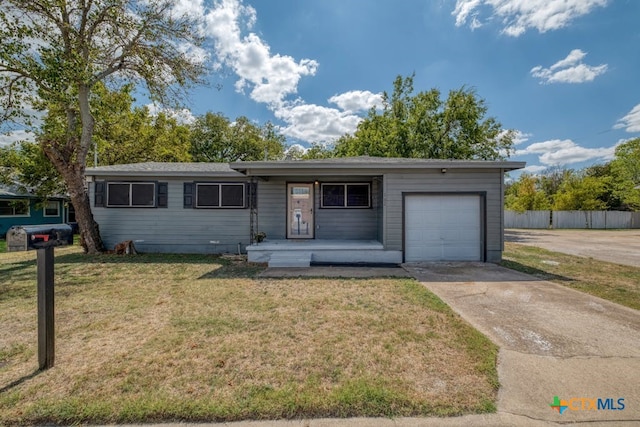 ranch-style house with covered porch, a front yard, and a garage