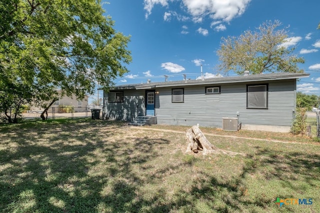 rear view of house featuring a yard and central AC