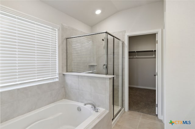 bathroom with tile patterned floors, separate shower and tub, and vaulted ceiling