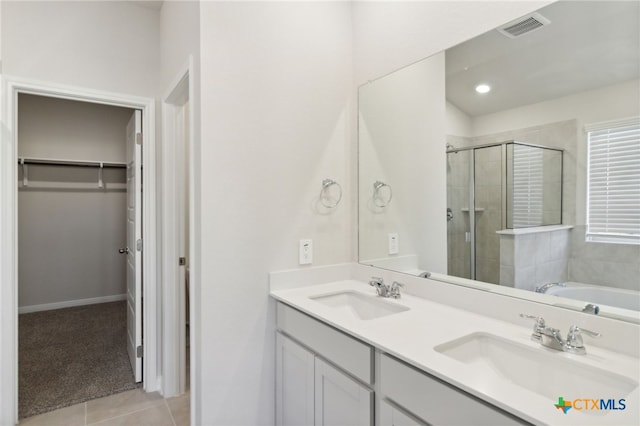 bathroom featuring tile patterned flooring, vanity, and separate shower and tub