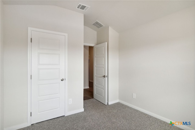 unfurnished bedroom featuring carpet and lofted ceiling