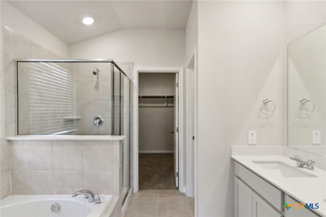 bathroom with tile patterned floors, vanity, separate shower and tub, and vaulted ceiling