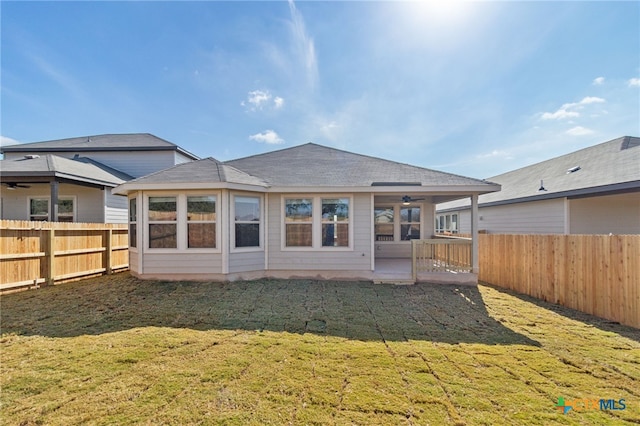 back of house with a lawn and ceiling fan