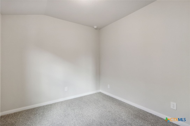 carpeted spare room featuring lofted ceiling