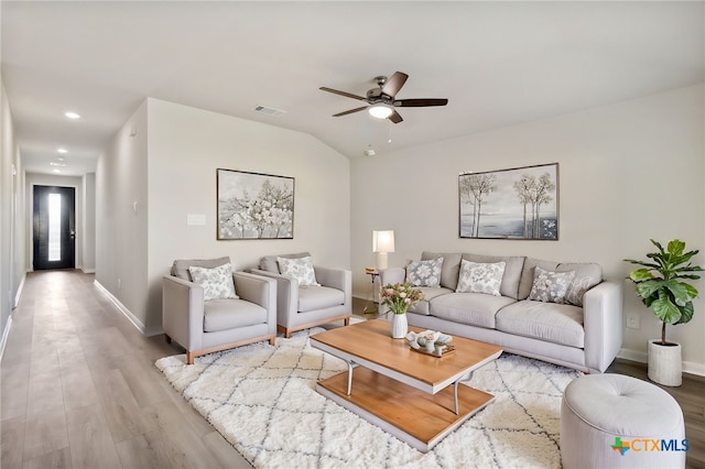 living room featuring ceiling fan, light hardwood / wood-style flooring, and lofted ceiling