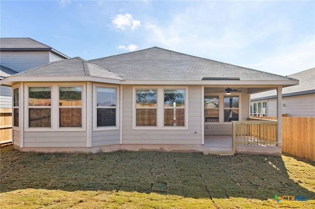 back of house featuring a yard and ceiling fan