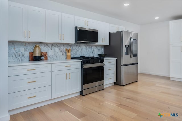 kitchen with stainless steel appliances, backsplash, light countertops, white cabinetry, and light wood-style flooring
