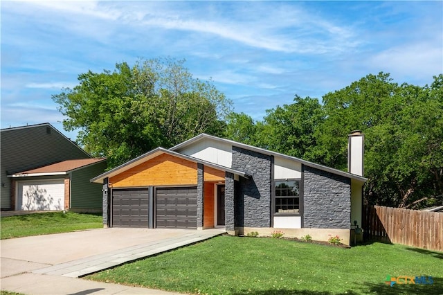 view of front of property with stone siding, driveway, an attached garage, and a chimney