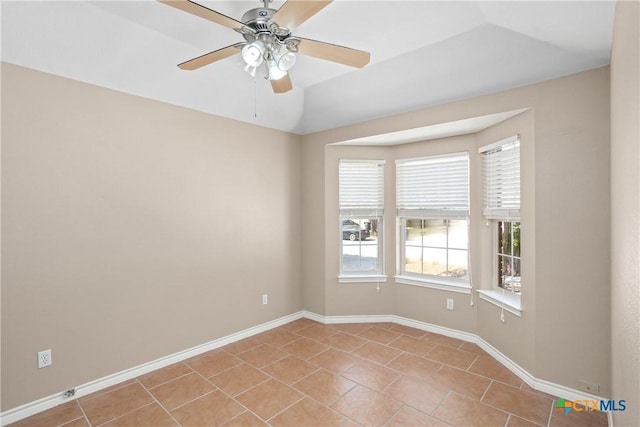 spare room featuring baseboards, a ceiling fan, and light tile patterned flooring