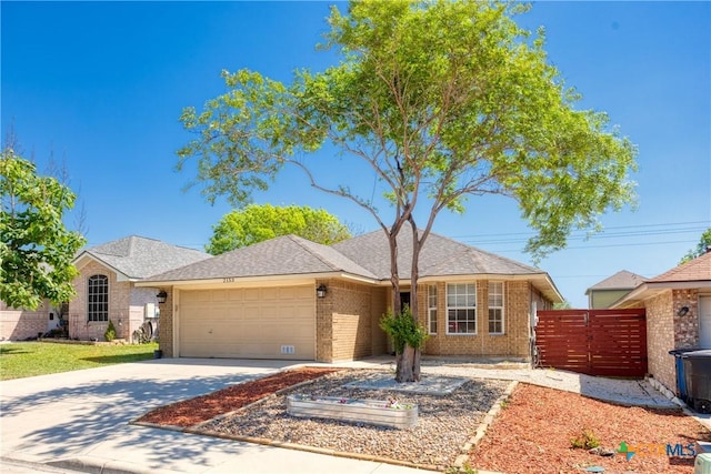 ranch-style home with fence, an attached garage, brick siding, a gate, and concrete driveway