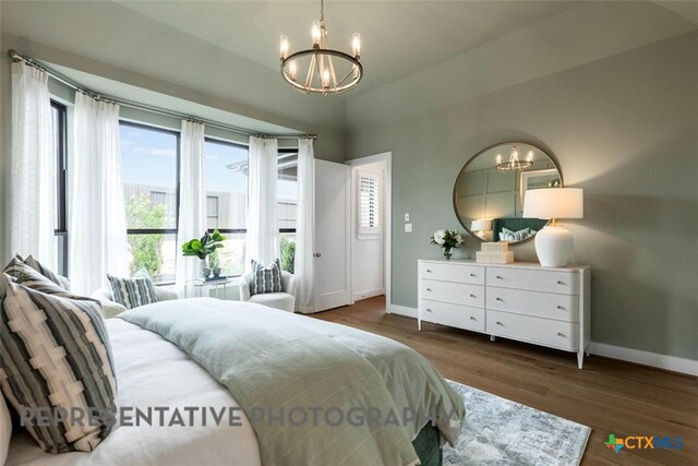 221 Dycus Bnd, Liberty Hill, TX 78642 - bedroom featuring a chandelier, baseboards, wood finished floors, and vaulted ceiling
