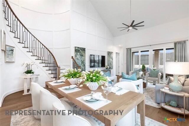 221 Dycus Bnd, Liberty Hill, TX 78642 - dining area featuring wood finished floors, high vaulted ceiling, stairs, and ceiling fan