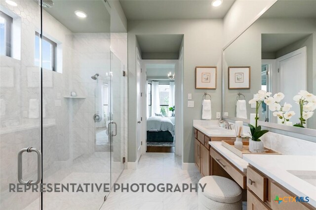 221 Dycus Bnd, Liberty Hill, TX 78642 - ensuite bathroom with vanity, plenty of natural light, and a shower stall