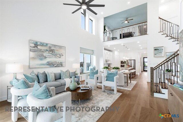 221 Dycus Bnd, Liberty Hill, TX 78642 - living room featuring ceiling fan, stairs, wood finished floors, and a towering ceiling