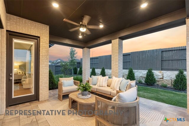 221 Dycus Bnd, Liberty Hill, TX 78642 - patio terrace at dusk featuring a ceiling fan, a fenced backyard, a patio area, and an outdoor hangout area