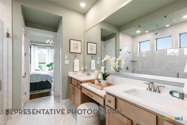 221 Dycus Bnd, Liberty Hill, TX 78642 - ensuite bathroom with a shower stall, double vanity, plenty of natural light, and recessed lighting