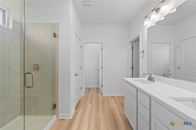 607 Killam Dr, Temple, TX 76502 - full bath with wood finished floors, a shower stall, double vanity, and baseboards