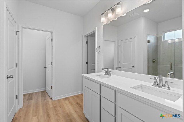 bathroom featuring vanity, hardwood / wood-style flooring, and a shower with shower door