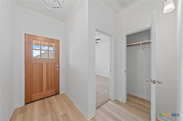 entryway with crown molding and light hardwood / wood-style flooring