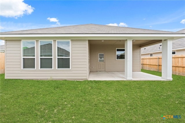 rear view of property featuring a yard and a patio area