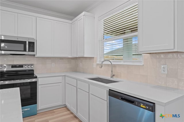 607 Killam Dr, Temple, TX 76502 - kitchen featuring appliances with stainless steel finishes, a sink, light countertops, white cabinetry, and crown molding