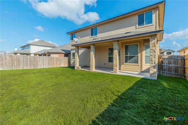 rear view of property featuring a yard and a patio