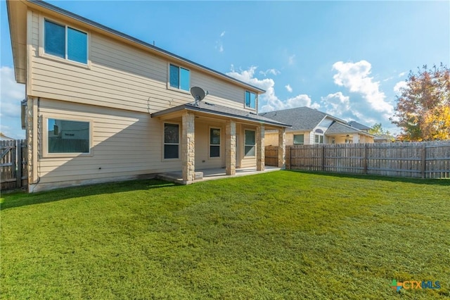 back of property with a lawn and a patio