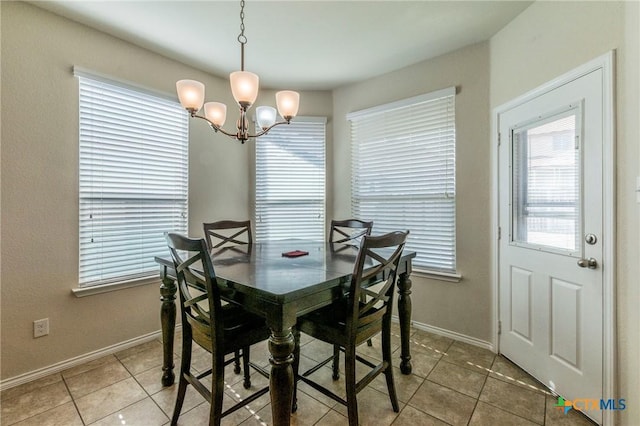 dining area featuring tile patterned flooring and an inviting chandelier