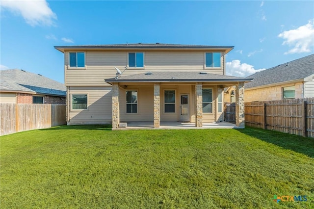 back of property with a lawn and a patio area