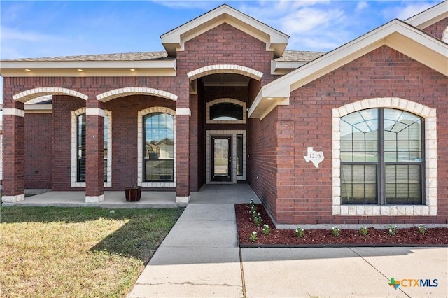 entrance to property featuring a lawn