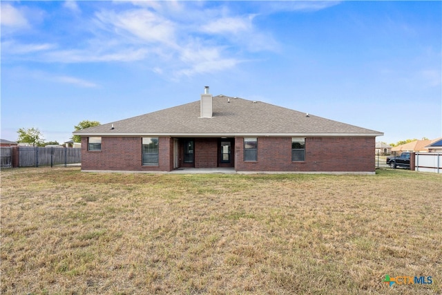 rear view of property with a lawn and a patio area