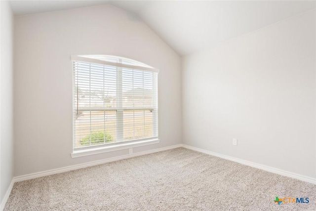 unfurnished room featuring carpet and lofted ceiling