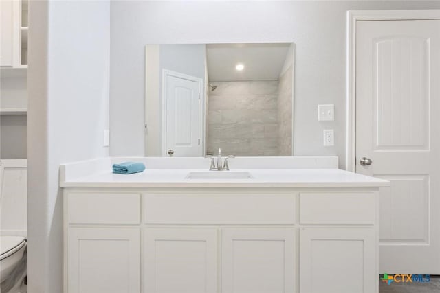 bathroom featuring a shower, vanity, and toilet