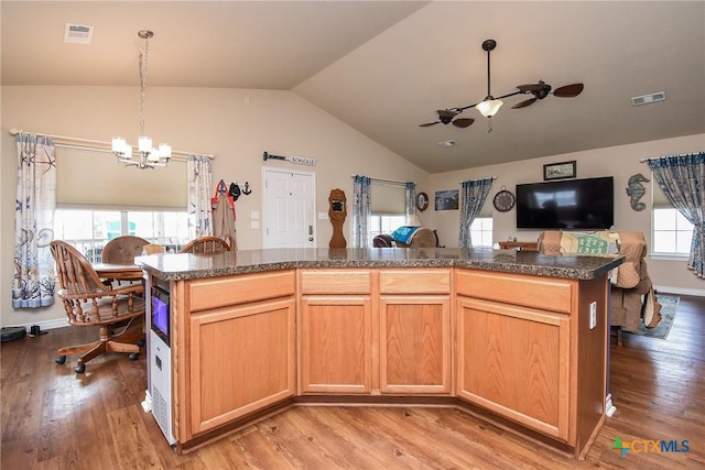 16 Peggy St, Palacios, TX 77465 - kitchen with light brown cabinets, lofted ceiling, ceiling fan with notable chandelier, light wood-type flooring, and a kitchen island