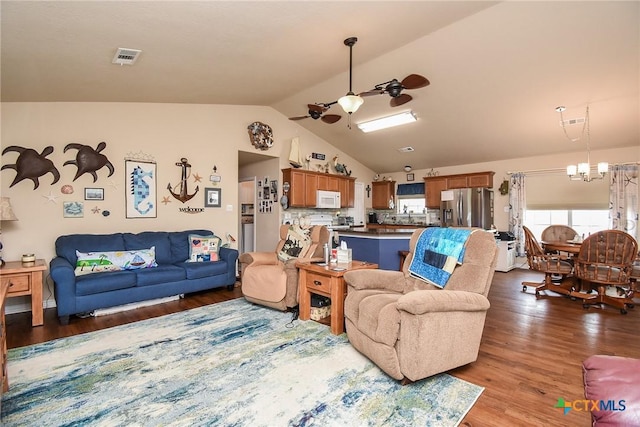 16 Peggy St, Palacios, TX 77465 - living room with vaulted ceiling, wood-type flooring, and ceiling fan with notable chandelier