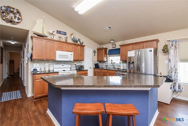 16 Peggy St, Palacios, TX 77465 - kitchen featuring decorative backsplash, appliances with stainless steel finishes, a kitchen bar, a kitchen island, and lofted ceiling