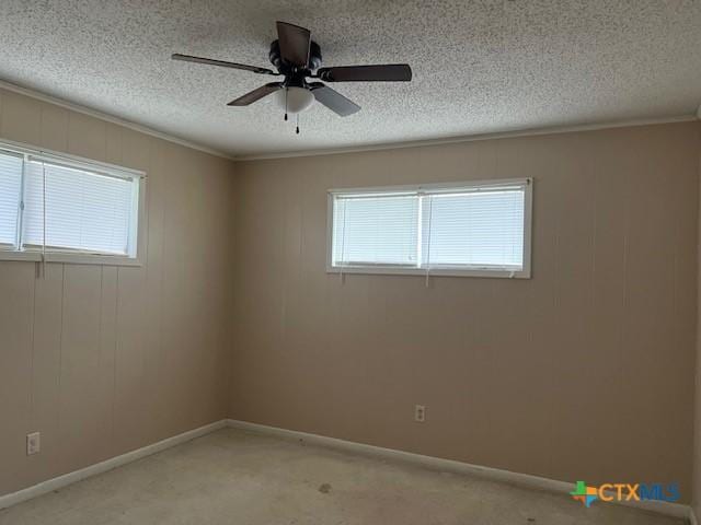 unfurnished room with a ceiling fan, baseboards, a textured ceiling, and light colored carpet