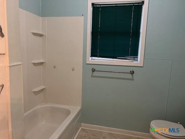 bathroom with shower / bathtub combination, baseboards, and toilet